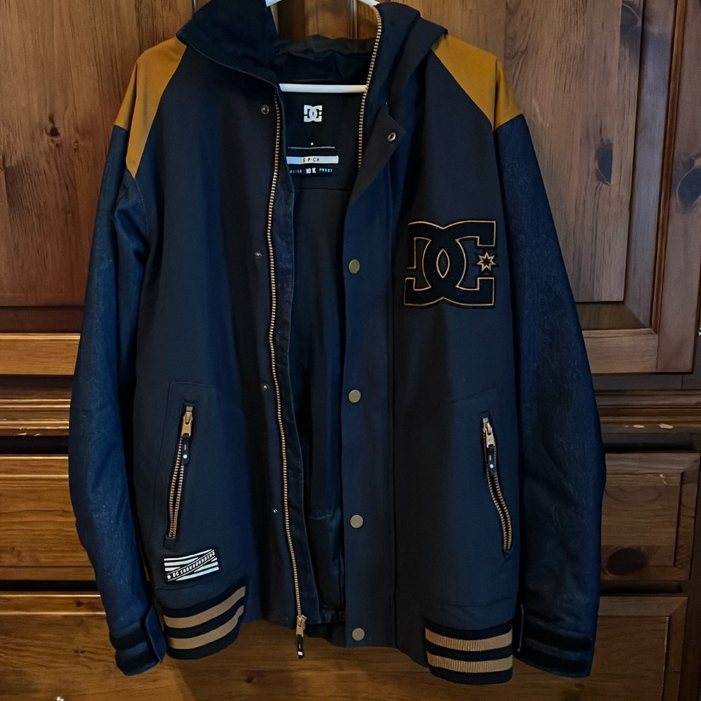 A blue and gold DC bomber coat